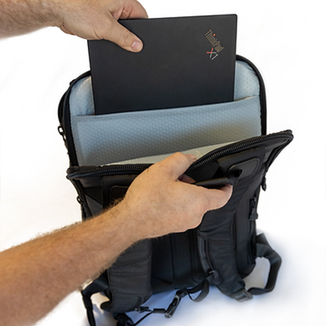 Hands placing a laptop into a compartment in the Grade Control Products Field Backpack