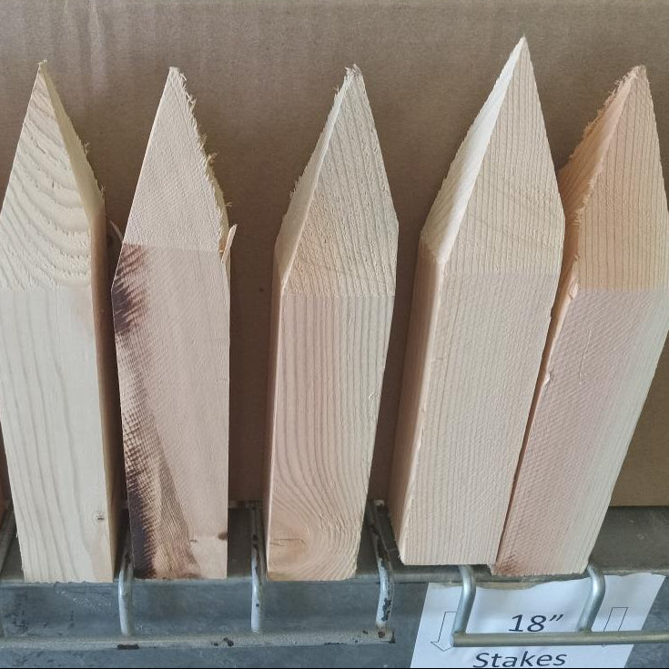 Set of wooden stakes with pointed tips on a display rack.