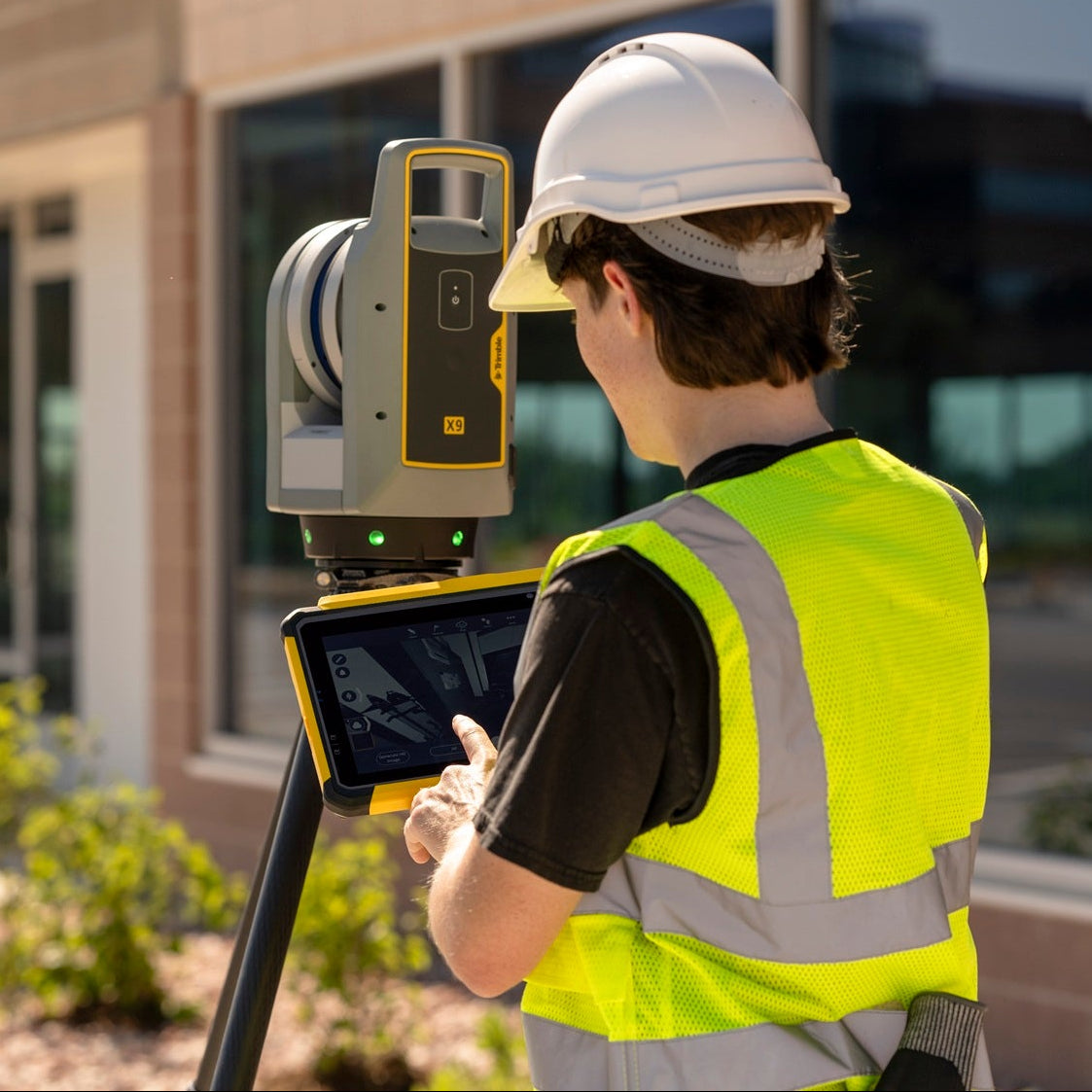 Trimble T110 Rugged Tablet held by surveyor next to Trimble X9 3D Scanner