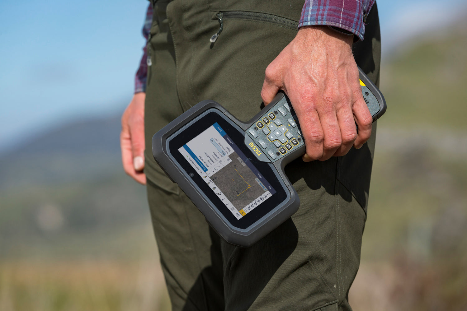 Surveyor holding TSC510 controller - rugged device for outdoor data collection and mapping